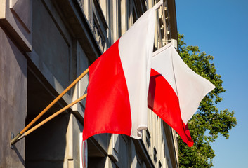 Two Polish national flags on a building in a slight wind