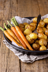 Roasted Vegetables in a Black Plate Wooden Background Vegetarian Dish Grilled Carrots and Potatoes Vertical