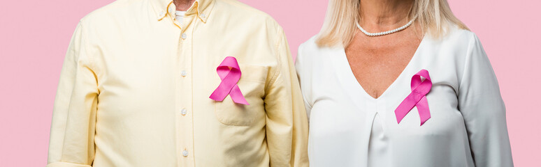 panoramic shot of retired couple with ribbons isolated on pink