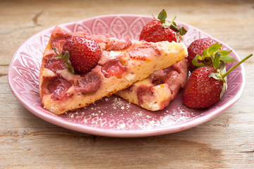 Piece of round strawberry berries tart pie pudding on pink plate on rustic wooden background