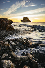 Orange sunset over a rocky coastline, Malaga Beach