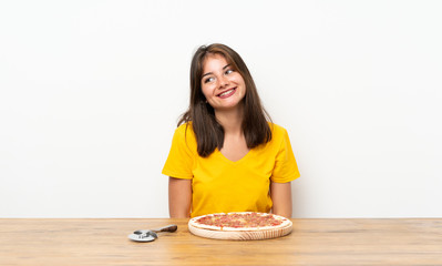 Caucasian girl with a pizza laughing and looking up