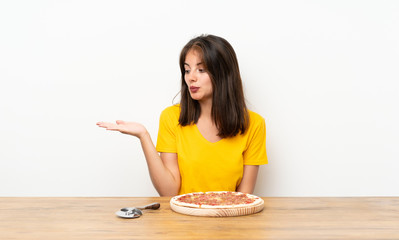 Caucasian girl with a pizza holding copyspace imaginary on the palm
