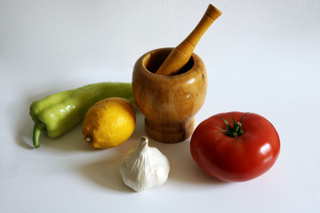Bodegon colorido con mortero, ajo, limón, tomate y pimiento
