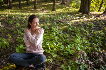Obraz premium Beautiful woman meditating in the forest on a sunny morning