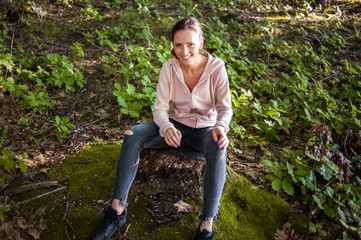 Beautiful woman meditating in the forest on a sunny morning