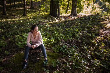 Beautiful woman meditating in the forest on a sunny morning