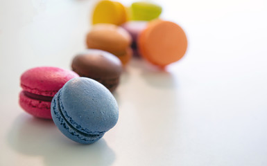 Colorful macarons on white background, close up view
