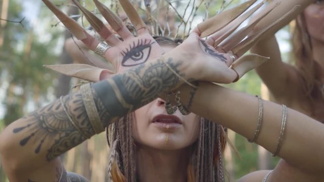 Group of great women dancers with make-up and in mystical fabulous costumes dancing groovy dance in the forest. Forest fairies, dryads have fun among the trees. Performance of dancers outdoors.
