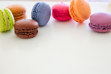Colorful macarons on white background, close up view