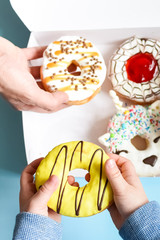 People hands grabbing donuts