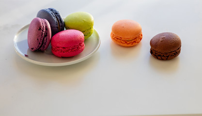 Colorful macarons on white background, close up view