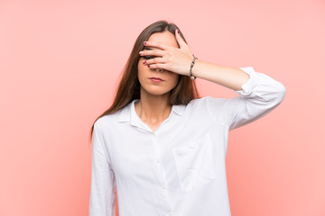 Young woman over isolated pink background covering eyes by hands