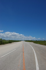 晴天の空と奥に続く直線道路