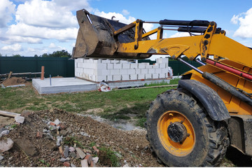 A bulldozer disposes of debris on the construction site of a private territory.