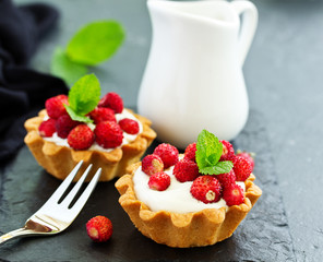 Wild strawberry tartlets with cream filling. delicious summer fruit mini tarts