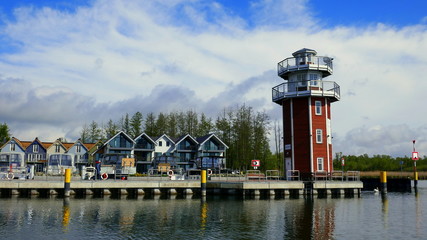 moderner roter Leuchtturm zeigt die Hafenausfahrt zum Plauer See in Mecklenburg - obrazy, fototapety, plakaty