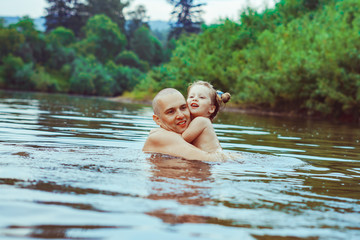 Fototapeta premium Dad and child bathe in the river