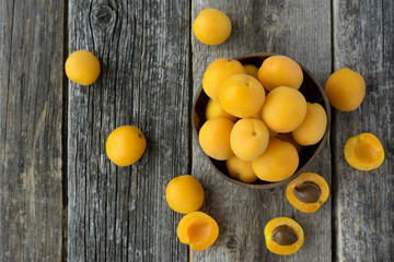 Fototapeta na wymiar Fresh apricots in bowl on wooden table