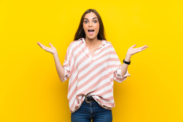 Young woman over isolated yellow background with shocked facial expression