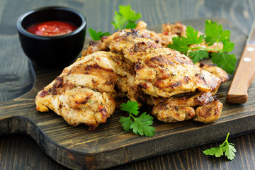 Grilled chicken fillet with tomato sauce and greens.