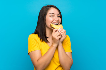 Young Mexican woman over isolated blue background