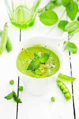 Green pea soup with croutons on wooden rustic background