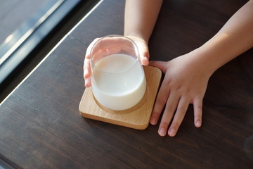 A girl hands holding a glass of fresh Milk.