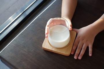 A girl hands holding a glass of fresh Milk.