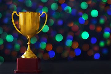 Winner hold trophy with abstract bokeh light background