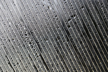 Water droplets on cellular polycarbonate, pattern and structure with variable scale and direction.