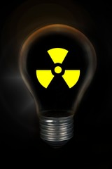 Light bulb with  radioactive nuclear symbol in front of black background.The bulb glass with...