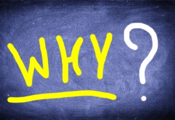 Yellow inscription Why? on old black chalkboard.Yellow sign Why? written in chalk on an old black chalkboard.