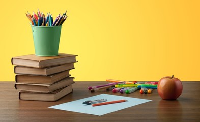 Stack of books and school blackboard