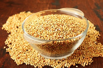 Green buckwheat on plate on wooden background