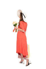 back view of elegant woman in hat and dress holding white tulips and shopping bags isolated on white