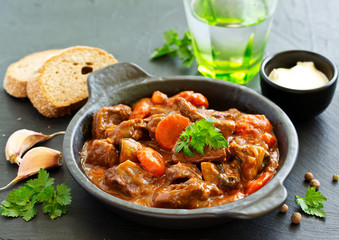 Beef stew in Burgundy. With carrots, onions, peas and champignons in wine. View from above.