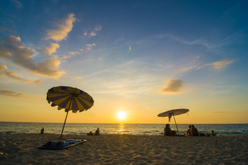 Blurred group of people enjoying sunset on sea beach