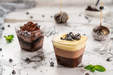 Tasty mousse dessert with jelly and berries in a glass on light background close up. Delicious dessert and candy bar, close up