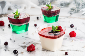 Tasty mousse dessert with jelly and berries in a glass on light background close up. Delicious dessert and candy bar, close up