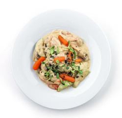 Hot salad with chicken meat, carrots, mushrooms, zucchini and cheese sauce isolated on white background. Healthy food, top view