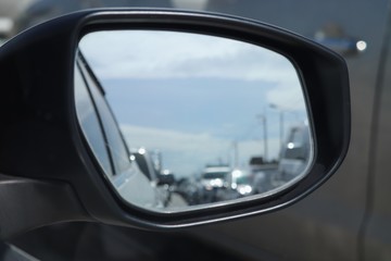 Fototapeta na wymiar blurred of traffic jam in wing mirror of car on the road in summer day