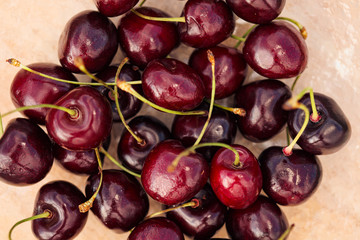 Red ripe sweet cherry in a glass bowl on green grass.