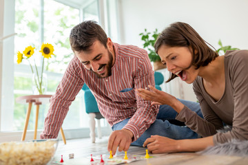 Couple playing board games at home