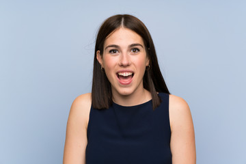 Fototapeta premium Young woman over isolated blue wall with surprise facial expression