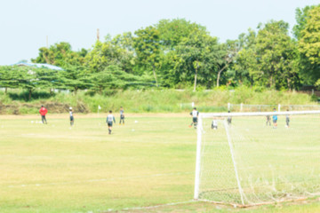 Blurred images of football field, people playing sports outside the city.