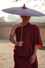 A young monk standing at Buddhist pagoda