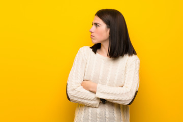 Fototapeta premium Young woman over isolated yellow wall portrait