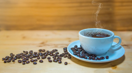 cup of coffee and beans on wooden table