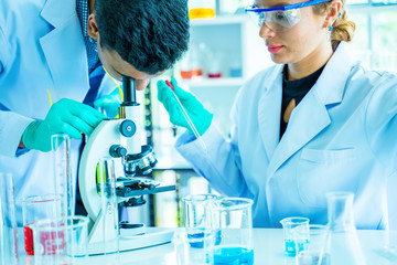 Two scientists conducting research in a lab environment.Analyze chemical formulas,biological test...